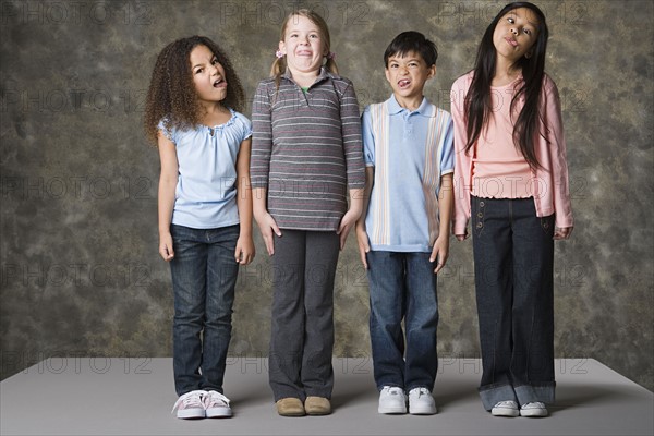 Children (8-9) making faces, studio shot. Photo : Rob Lewine