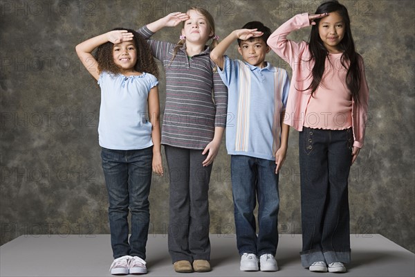 Children (6-7, 8-9) saluting, studio shot. Photo: Rob Lewine