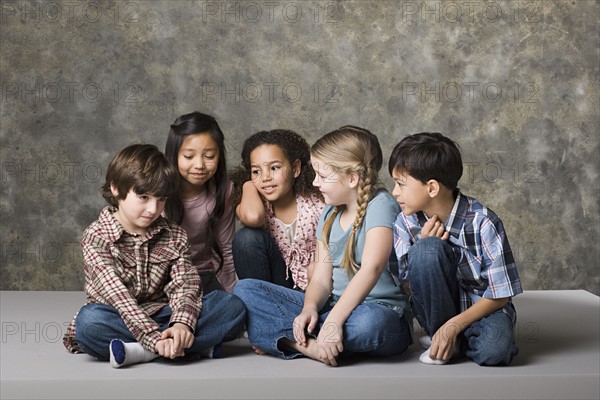 Children (6-7, 8-9) comforting fiend, studio shot. Photo : Rob Lewine