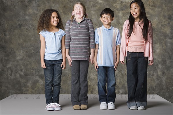 Children (8-9) laughing together, studio shot. Photo: Rob Lewine