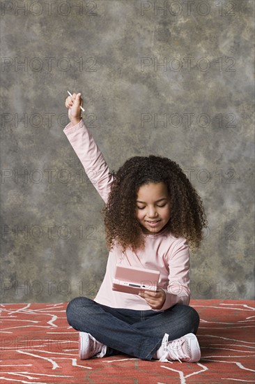 Girl (8-9) playing game, studio shot. Photo : Rob Lewine