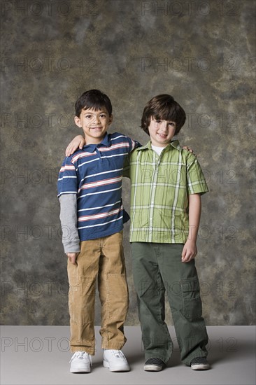 Two boys (6-7, 8-9) standing together, studio shot. Photo: Rob Lewine