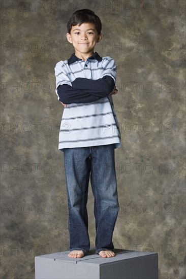 Smiling boy (8-9) standing, studio shot. Photo : Rob Lewine