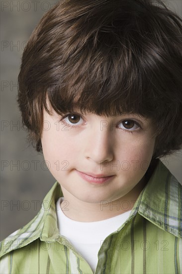 Portrait of smiling (6-7) boy, studio shot. Photo: Rob Lewine