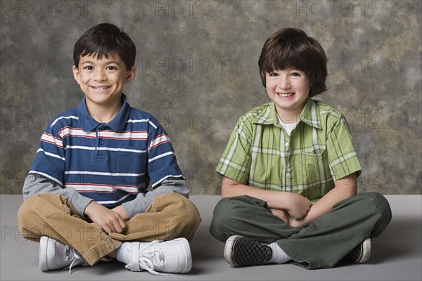 Portrait of two boys (6-7, 8-9) smiling, studio shot. Photo : Rob Lewine