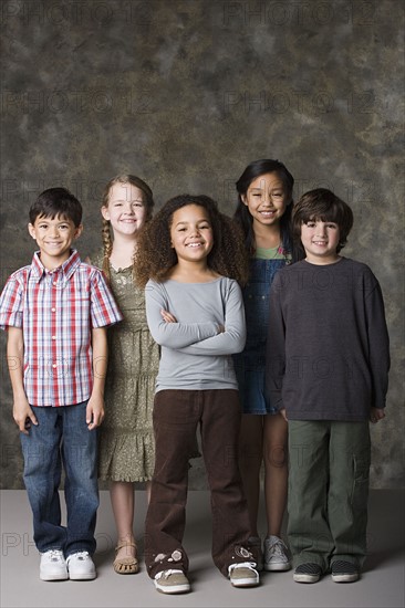 Children (6-7, 8-9) posing together, studio shot. Photo : Rob Lewine