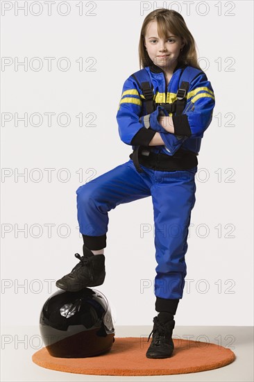 Portrait of girl (8-9) dressed as racing driver, studio shot. Photo: Rob Lewine