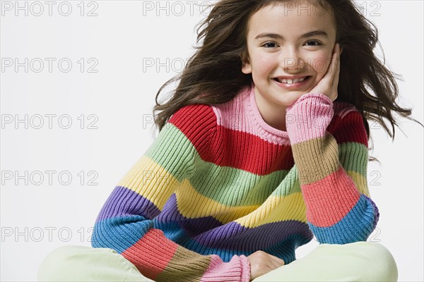 Portrait of smiling girl (8-9), studio shot. Photo : Rob Lewine