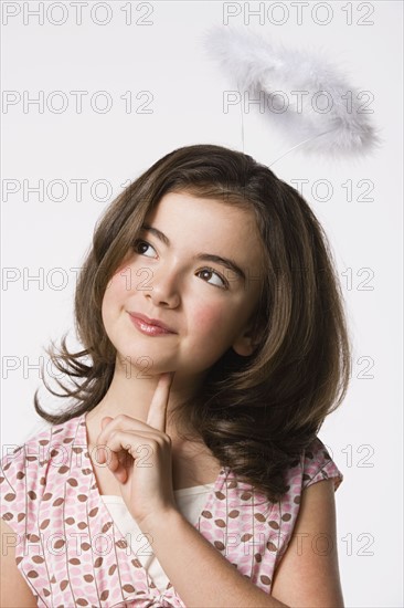 Girl (8-9) wearing halo, studio shot. Photo : Rob Lewine