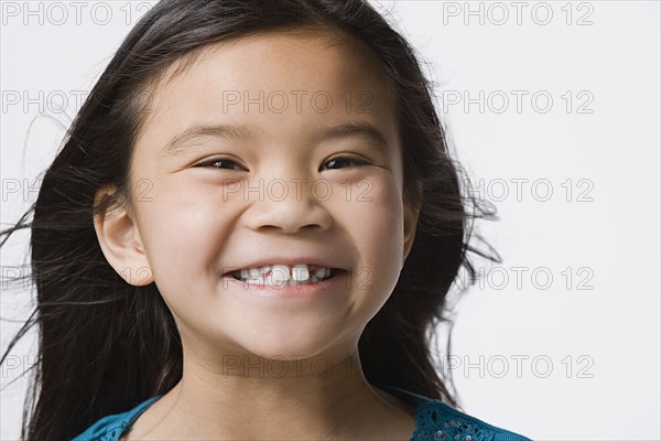 Portrait of smiling girl (8-9), studio shot. Photo : Rob Lewine