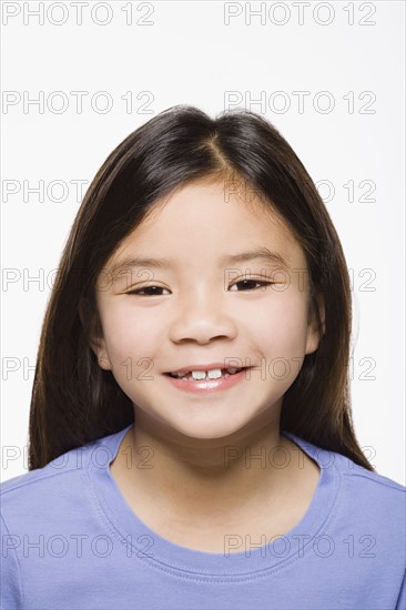 Portrait of smiling girl (8-9), studio shot. Photo : Rob Lewine