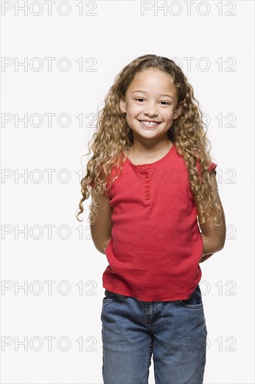 Portrait of smiling girl (8-9), studio shot. Photo: Rob Lewine