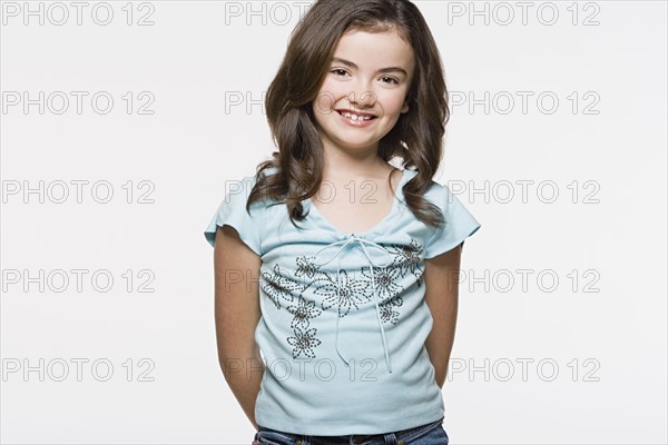 Portrait of smiling girl (8-9), studio shot. Photo : Rob Lewine