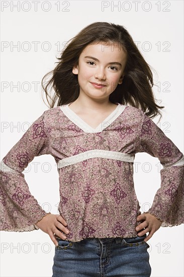 Portrait of girl (8-9) with hands on hips, studio shot. Photo : Rob Lewine