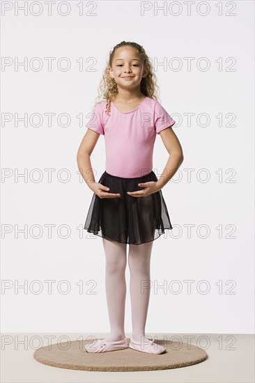 Studio portrait of smiling girl (8-9) in ballet costume. Photo: Rob Lewine