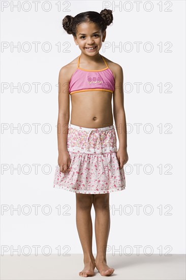 Studio portrait of smiling girl (8-9) with hair buns. Photo : Rob Lewine