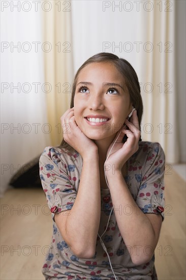 Girl 10-11) listening music on headphones. Photo : Rob Lewine