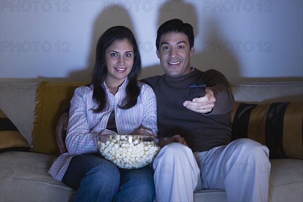 Couple watching tv on sofa. Photo : Rob Lewine