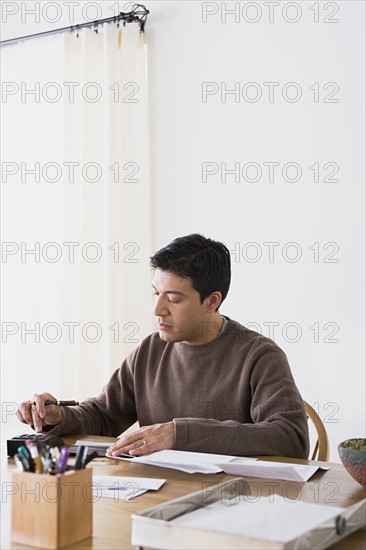 Man doing paperwork at home. Photo : Rob Lewine