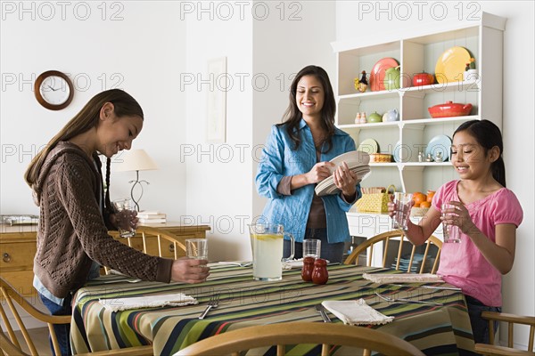 Mother with two daughters (8-9, 10-11) in kitchen. Photo : Rob Lewine