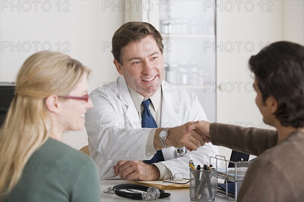 Doctors shaking hands in office. Photo: Rob Lewine