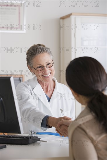 Smiling female doctor shaking hand with patient in her office. Photo: Rob Lewine
