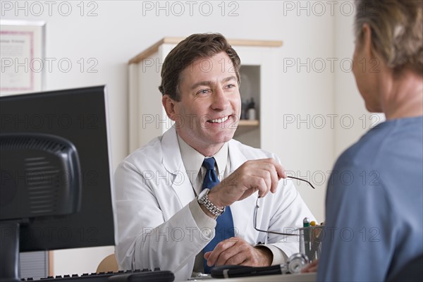 Male doctor talking to patient in his office. Photo: Rob Lewine