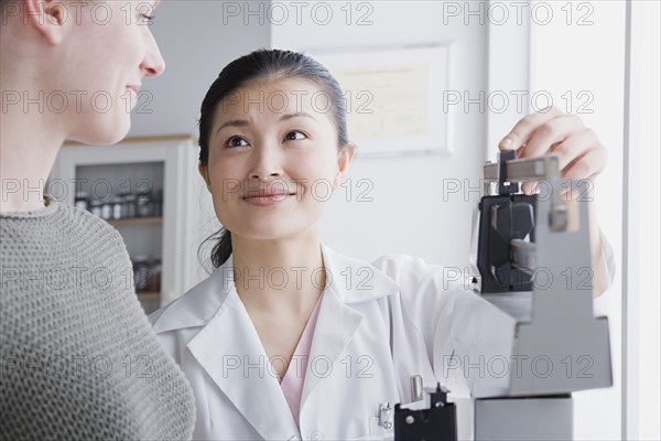 Close up of female doctor measuring woman's weight. Photo: Rob Lewine