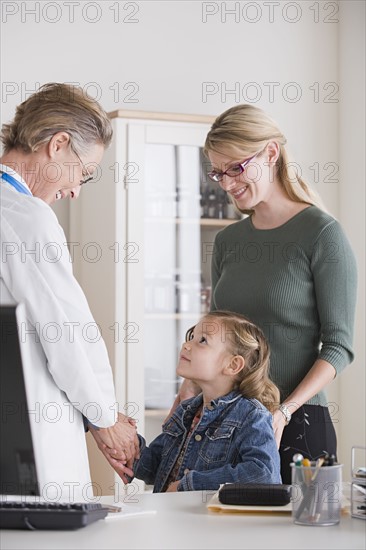 Female shaking hand with small girl (4-5) in her office. Photo : Rob Lewine