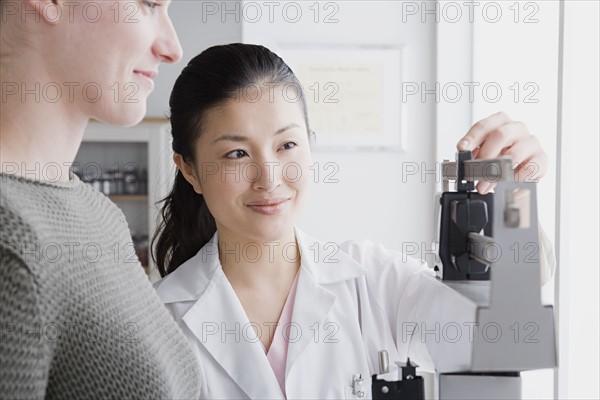 Close up of female doctor measuring woman's weight. Photo : Rob Lewine