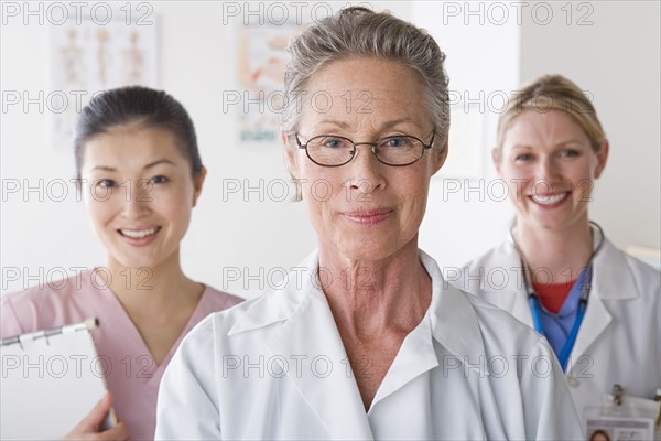 Portrait of three smiling female doctors. Photo : Rob Lewine