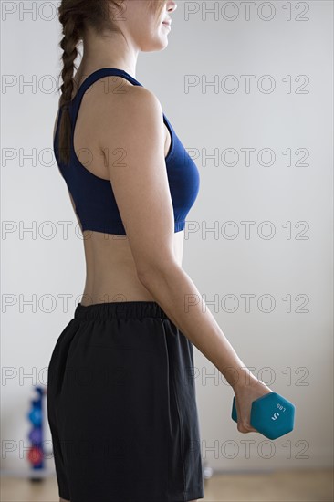 Woman lifting weights in gym. Photo : Rob Lewine