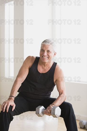 Mature man an lifting weights in gym. Photo : Rob Lewine