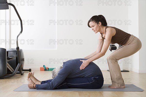Woman assisting man in exercise in gym. Photo : Rob Lewine