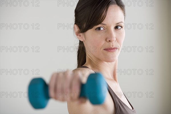 Portrait of woman lifting dumbbell. Photo: Rob Lewine