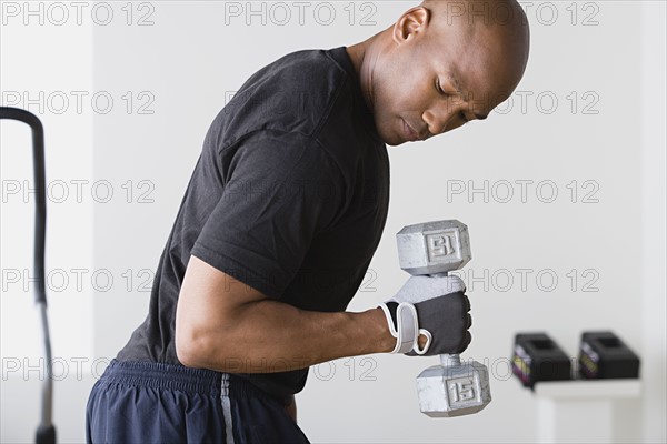Young man lifting weights in gym. Photo: Rob Lewine