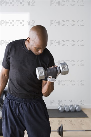 Man lifting dumbbells. Photo : Rob Lewine