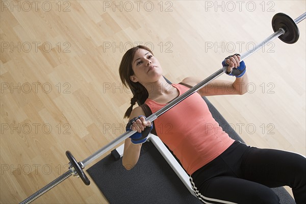 Woman lifting barbell. Photo : Rob Lewine