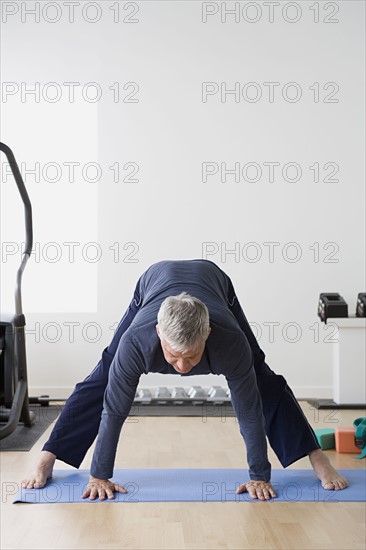 Man stretching in gym. Photo : Rob Lewine