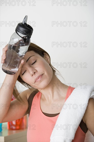 Tired female athlete wiping out sweat from forehead. Photo : Rob Lewine