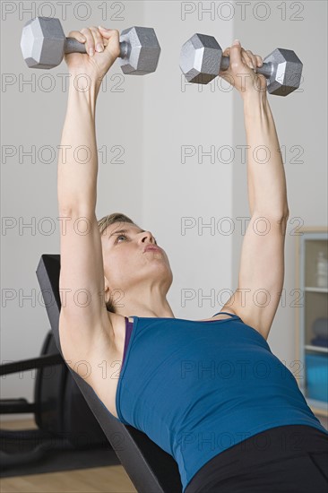 Woman lifting dumbbells. Photo : Rob Lewine
