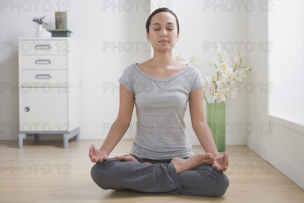 Woman meditating at home. Photo : Rob Lewine