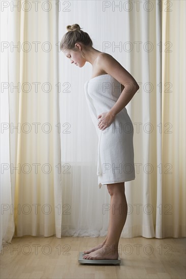 Woman standing on weight scale. Photo : Rob Lewine