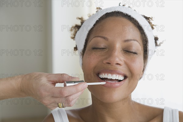 Woman having make-up applied. Photo : Rob Lewine