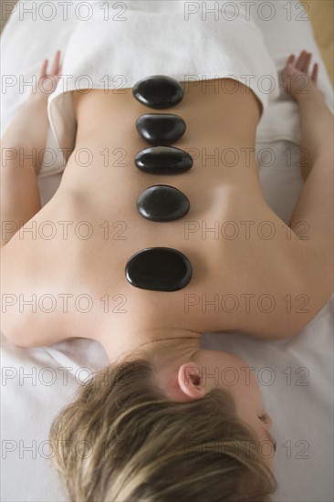 Woman enjoying hot stone therapy. Photo : Rob Lewine