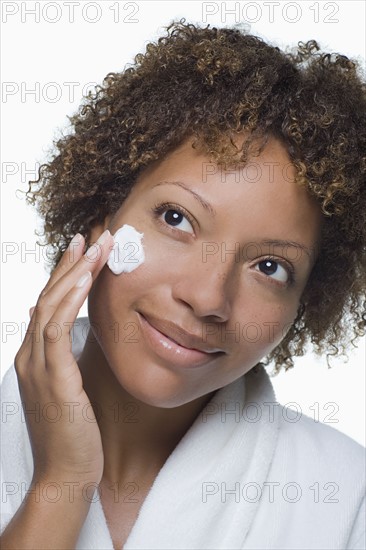 Attractive woman applying moisturizer. Photo : Rob Lewine