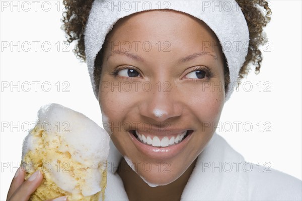 Portrait of attractive woman holding bath sponge. Photo : Rob Lewine