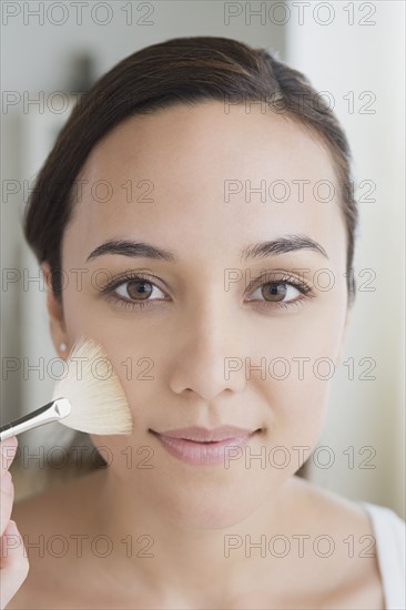 Woman applying make-up. Photo : Rob Lewine