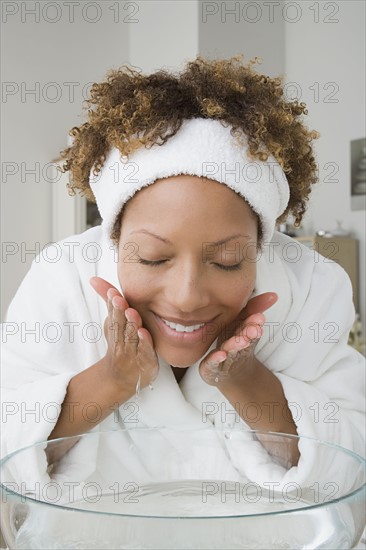 Woman washing face. Photo : Rob Lewine