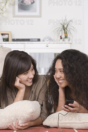 Two friends listening to mp3 player. Photo : Rob Lewine